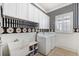 Laundry room with washer, dryer, utility sink, and black and white striped wallpaper at 15707 Crystal Waters Dr, Wimauma, FL 33598