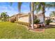 Landscaped yard with tan house and palm trees at 15767 Crystal Waters Dr, Wimauma, FL 33598