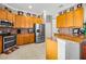 Bright kitchen boasts stainless steel appliances and warm wood cabinets at 15767 Crystal Waters Dr, Wimauma, FL 33598