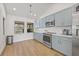 Modern kitchen with light blue cabinets, white quartz countertops, and stainless steel appliances at 16104 Stowe Ct, Tampa, FL 33647