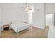 Bright bedroom with white bedding, hardwood floors and ceiling fan at 16104 Stowe Ct, Tampa, FL 33647