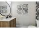 Stylish bathroom with modern vanity, framed art, and a round mirror at 18803 15Th St, Lutz, FL 33549