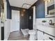 Modern bathroom with dark tile shower, white vanity, and wood-look floors at 18803 15Th St, Lutz, FL 33549