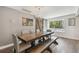 Elegant dining room with farmhouse table, bench seating, and large window at 18803 15Th St, Lutz, FL 33549