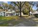 White house with covered patio, large yard, and mature trees at 18803 15Th St, Lutz, FL 33549