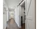 Bright hallway with hardwood floors and barn door leading to an office at 18803 15Th St, Lutz, FL 33549