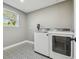 Bright laundry room with patterned tile floor and modern washer and dryer at 18803 15Th St, Lutz, FL 33549