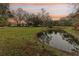 Peaceful pond view of a ranch style home at sunset at 3009 Jim Johnson Rd, Plant City, FL 33566