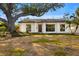 White single-story home with a large oak tree and front yard at 431 Rafael Ne Blvd, St Petersburg, FL 33704