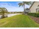 Spacious backyard with lake view, screened patio, and lush landscaping at 4339 Cheval Blvd, Lutz, FL 33558