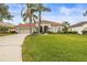 Single-story home with tile roof, palm trees, and a well-manicured lawn at 4339 Cheval Blvd, Lutz, FL 33558