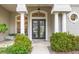 Elegant entryway with double doors, columns, and lush landscaping at 4339 Cheval Blvd, Lutz, FL 33558