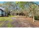 Landscaped backyard with a wooden shelter and trees at 4540 Oakfield Cir, Dade City, FL 33523