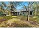 Home's rear elevation, showcasing a screened porch and yard at 4540 Oakfield Cir, Dade City, FL 33523