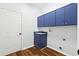 Functional laundry room, featuring blue cabinets and vinyl flooring at 4540 Oakfield Cir, Dade City, FL 33523