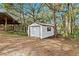 White storage shed with metal door, nestled in a wooded area at 4540 Oakfield Cir, Dade City, FL 33523