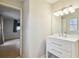 Clean bathroom with a white vanity and mirror, and view to bedroom at 4920 Steel Dust Ln, Lutz, FL 33559