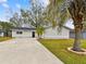 Newly renovated home with a large driveway and mature palm trees at 4920 Steel Dust Ln, Lutz, FL 33559