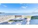 Tranquil ocean view featuring a rustic bench and scattered rocks on the shoreline, perfect for relaxation at 5000 Culbreath Key Way # 2-202, Tampa, FL 33611