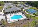 Aerial view of a community clubhouse with a pool and tennis courts at 5149 Jennings Trl, Brooksville, FL 34601