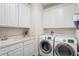 Laundry room with washer, dryer, cabinets, and utility sink at 5149 Jennings Trl, Brooksville, FL 34601