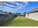 Large grassy backyard with wooden fence at 6932 Oakcrest Way, Zephyrhills, FL 33542