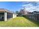 Fenced backyard with grassy area and clothesline at 6932 Oakcrest Way, Zephyrhills, FL 33542