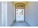 White front door entryway with arched window and glass at 6932 Oakcrest Way, Zephyrhills, FL 33542