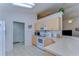 Kitchen features white appliances and light wood cabinets at 6932 Oakcrest Way, Zephyrhills, FL 33542