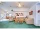 Living room with vaulted ceilings, beige couches and green carpet at 6932 Oakcrest Way, Zephyrhills, FL 33542