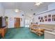 Open living room with high ceilings, a wood cabinet, and green carpet at 6932 Oakcrest Way, Zephyrhills, FL 33542