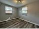 Bedroom with gray walls, wood-look floors, and two windows at 6985 82Nd N Ave, Pinellas Park, FL 33781