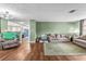 Living room with hardwood floors, green walls, and view of kitchen at 7051 Nova Scotia Dr, Port Richey, FL 34668