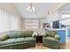 Cozy living room features green sofas and a view into the kitchen at 7051 Nova Scotia Dr, Port Richey, FL 34668