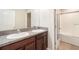 Bathroom with double vanity, granite countertop, and bathtub at 7610 Blue Iris Ln, Tampa, FL 33619