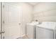 Laundry room with washer, dryer, and shelving at 7610 Blue Iris Ln, Tampa, FL 33619