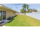 Large backyard with grassy lawn and white fence at 8310 Archwood Cir, Tampa, FL 33615