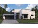 Modern two-story home with dark gray garage door and stone accents at 8421 Golden Beach Ct, Parrish, FL 34219