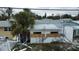 House with storm damage and plywood covering windows at 14236 Palm St, Madeira Beach, FL 33708
