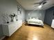Main bedroom with white dresser, light green bedding, and hardwood floors at 15906 Country Farm Pl, Tampa, FL 33624
