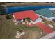 Aerial view of a charming residence with a red roof and well-kept lawn, set against a serene lake backdrop at 1723 Wolf Laurel Dr, Sun City Center, FL 33573