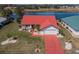 Aerial shot of a charming residence with a red roof and well-kept lawn, set against a serene lake backdrop at 1723 Wolf Laurel Dr, Sun City Center, FL 33573