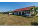 Rear view of a single-story home featuring sliding glass doors and a spacious lawn at 1723 Wolf Laurel Dr, Sun City Center, FL 33573