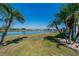 Backyard with a large pond view and lovely palm trees at 1723 Wolf Laurel Dr, Sun City Center, FL 33573
