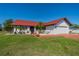 Charming single-story home featuring a red tile roof, white exterior, well-manicured lawn, and an attached two-car garage at 1723 Wolf Laurel Dr, Sun City Center, FL 33573
