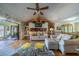 Bright living room features wood floors, vaulted ceiling with fan, and sliding glass doors to the lanai at 1723 Wolf Laurel Dr, Sun City Center, FL 33573