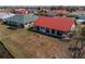 Aerial view of a home with a red roof in a residential neighborhood, featuring a spacious backyard and green landscaping at 1723 Wolf Laurel Dr, Sun City Center, FL 33573
