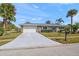 Ranch home with white garage door and palm trees at 1761 Eaton Ne Dr, Clearwater, FL 33756