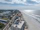 Aerial view of beachfront property, showcasing the ocean, beach, and nearby buildings at 19440 Gulf Blvd # 301, Indian Rocks Beach, FL 33785