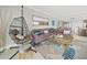 Relaxing living room featuring a hanging chair and sectional sofa at 19440 Gulf Blvd # 301, Indian Rocks Beach, FL 33785